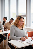 Portrait of woman making notes in class