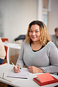 Portrait of woman making notes in class