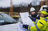 Construction engineers discussing project at construction site