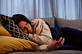 Woman on sofa using cell phone