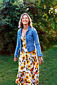 Lächelnde Frau im Garten stehend