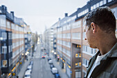 Man looking through window at street