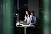 Man and woman working late in office