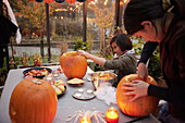 Girls carving pumpkins in greenhouse
