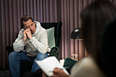 Man sitting in armchair at therapy session