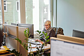 Smiling woman using computer in office