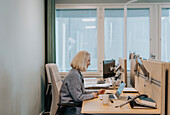 Smiling woman using laptop in office