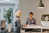 Smiling women talking in office