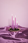Pink candles on satin fabric