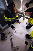 Engineers checking plans at building site