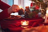 Eine Person zündet zu Hause Weihnachtskerzen an