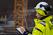 Female engineer using digital tablet at building site