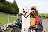 Bauer mit Hund am Steuer eines Vierrads