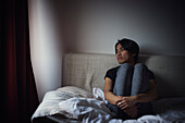 Pensive man sitting on sofa and looking through window