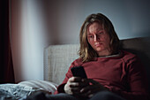 Man on bed using cell phone