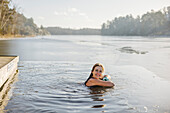 Frau beim Schwimmen im See im Winter