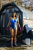 Frau bereitet sich auf das Schwimmen vor, Sauna im Hintergrund
