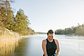 Smiling woman wearing swimwear at river