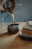 Traditional semla bun on plate and pouring coffee