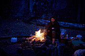 Man sitting at campfire at dusk