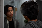 Young man looking in mirror