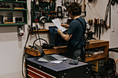 Blacksmith looking at document in workshop