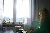 Pensive teenage girl sitting at table