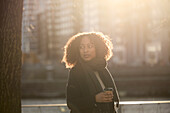 Beautiful woman with takeaway coffee posing on street