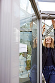 Ansicht einer Frau bei der Reparatur eines Dachfensters