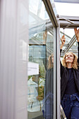 View of woman repairing roof window