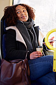 Young woman listening music in bus