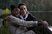 Junge Frauen sitzen zusammen am See