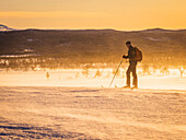 Ansicht eines Mannes beim Skifahren bei Sonnenuntergang