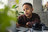 Boy at home using laptop