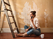 Woman talking via cell phone during house renovation