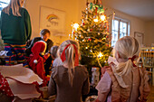 Familie beim Feiern neben dem Weihnachtsbaum