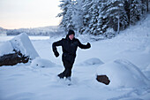 Frau spielt im Schnee in Winterlandschaft