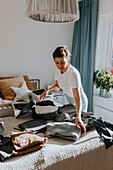 Woman folding clothes in bedroom