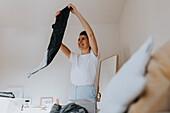 Woman folding clothes in bedroom