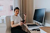 Woman at desk using cell phone