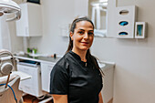 Female dentist standing in office