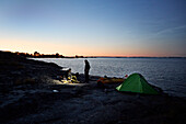 Blick auf die Touristen auf dem Campingplatz am Meer bei Sonnenuntergang