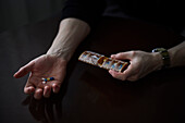 Frauenhände halten Schachtel mit Pillen