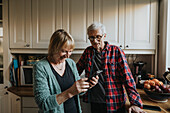 Älteres Ehepaar benutzt Smartphone zu Hause