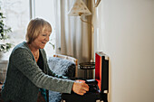 Ältere Frau benutzt zu Hause ein Grammophon