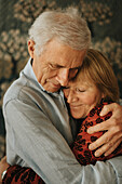 Senior couple hugging at home