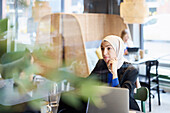 Frau mit Kopftuch in einem Café sitzend