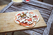 Homemade pizza on wooden cutting board