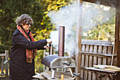 Woman starting fire in outdoor oven