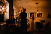 Father and daughters decorating Christmas tree